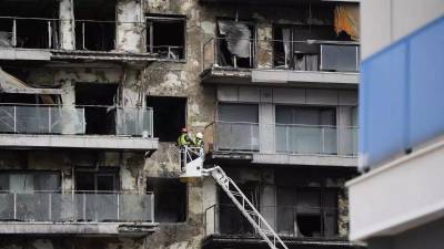 Bomberos trabajan en la limpieza del edificio incendiado, en el barrio del Campanar.