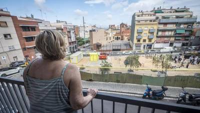 Una vecina contempla el solar en el que se van a construir unas viviendas sociales en El Carmel de Barcelona.