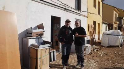 Recicleitor Maker y Miguel Santiago posan ante la casa que están reconstruyendo.