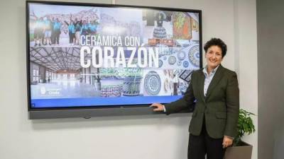 La alcaldesa de Onda, Carmina Ballester, posa junto al cartel de la campaña solidaria Cerámica con corazón.